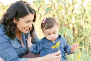 little daughter looking a sunflower