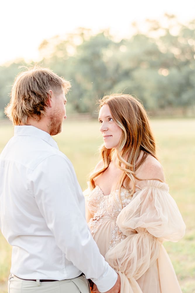 wife looking at her husband lovingly during maternity session