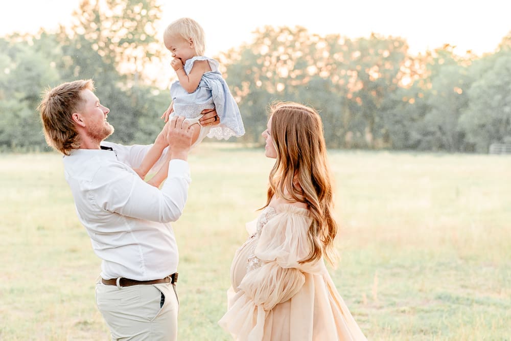 father holding his littler girl in the air