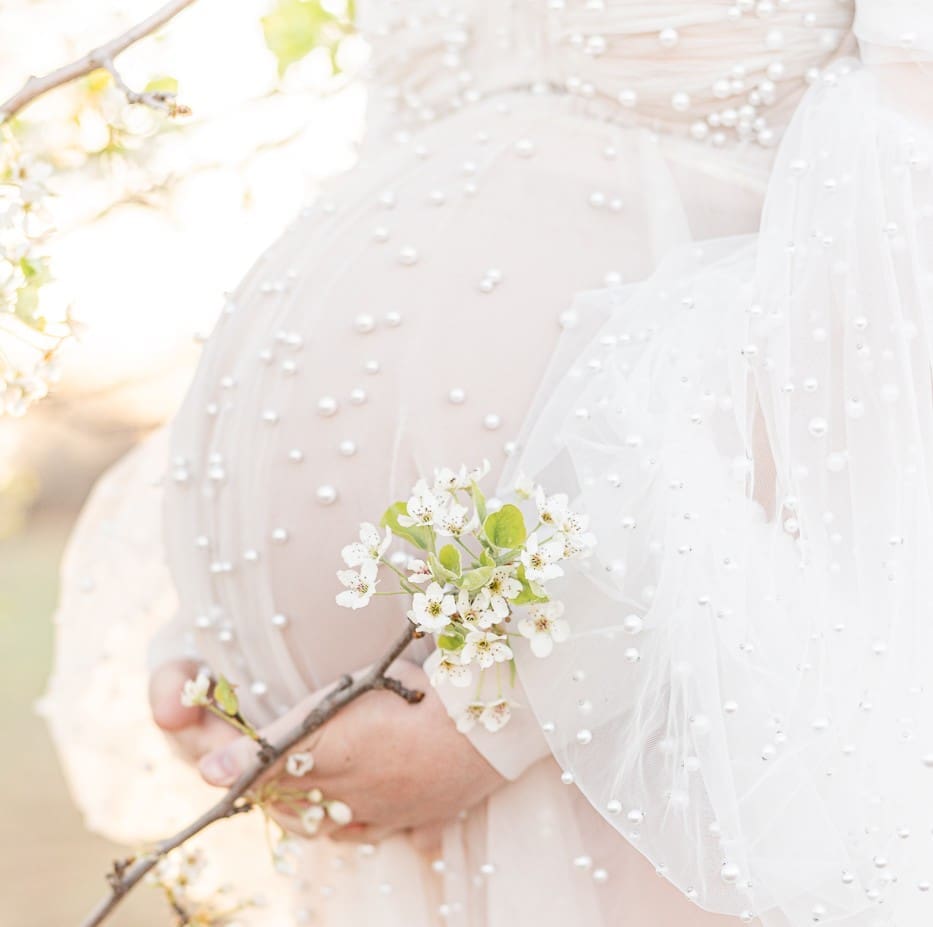 pearled white maternity gown with long puff sleeves with a Bradford pear tree flower