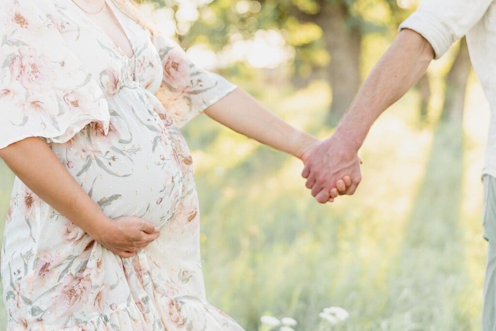 close up of first time parents holding hands during maternity session